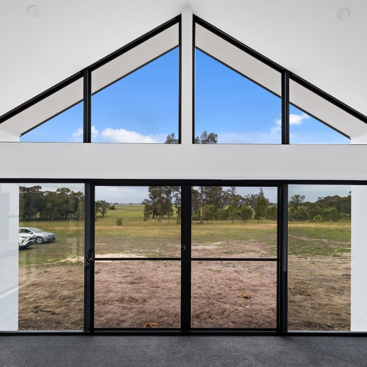 Light-filled interior with a pitched ceiling and full-height black-framed windows